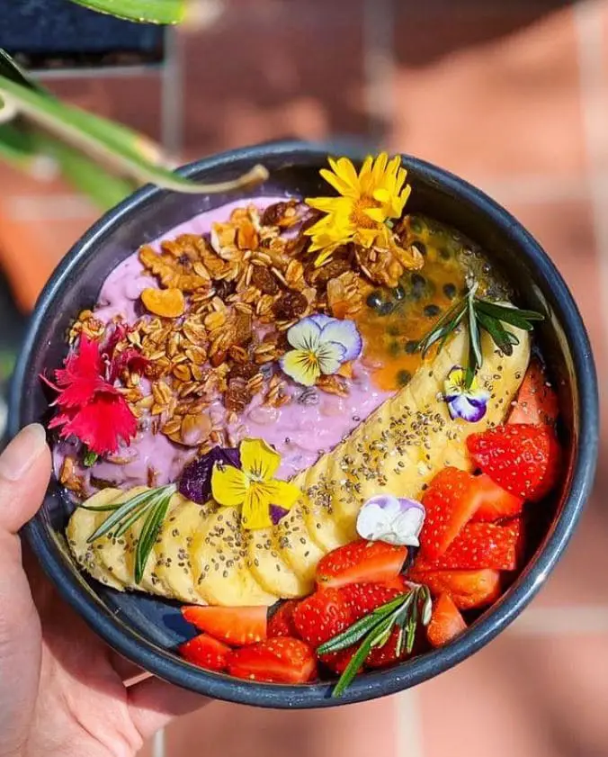 granola yogurt bowl by grounded 22 cafe serves fresh colorful and edible flowers as part of their mix