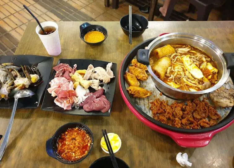 food plates on the table with a hotpot stove ready at zhong hua hotpot