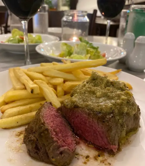 close up view of medium rare steak by steak frites