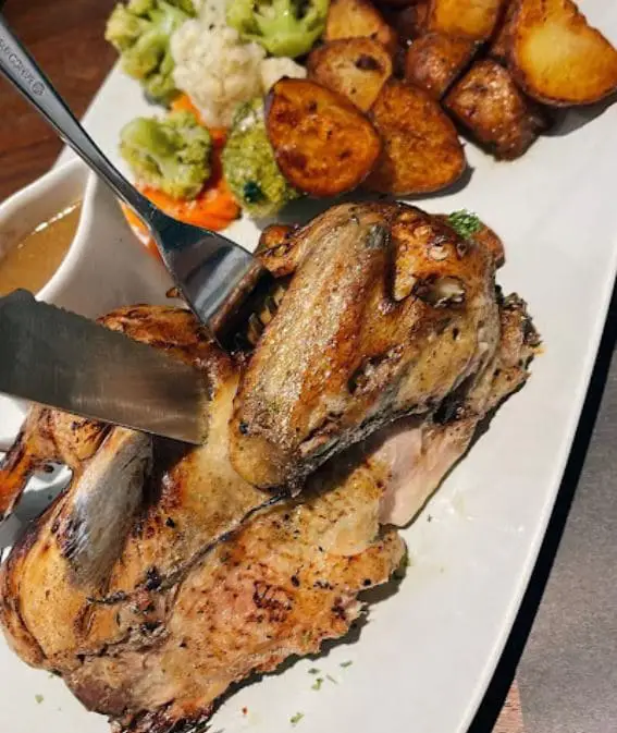 half chicken roast and potatoes served in ll bacaro