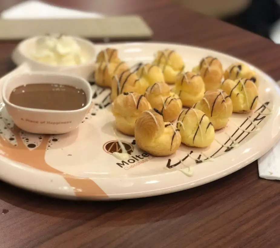 little puffs and chocolate dip served in molten cafe