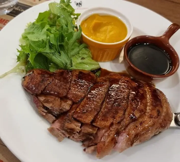 steak with salad and two in house sauce at two frenchies cafe bistro in penang