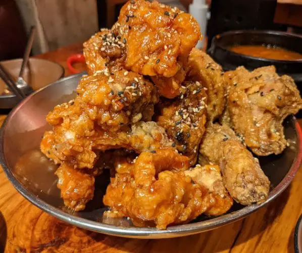 juicy korean fried chicken stacked up to a mountain in sin manbok