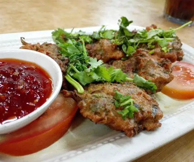 some thai fried chicken in ghee seng served with their vibrant chili paste